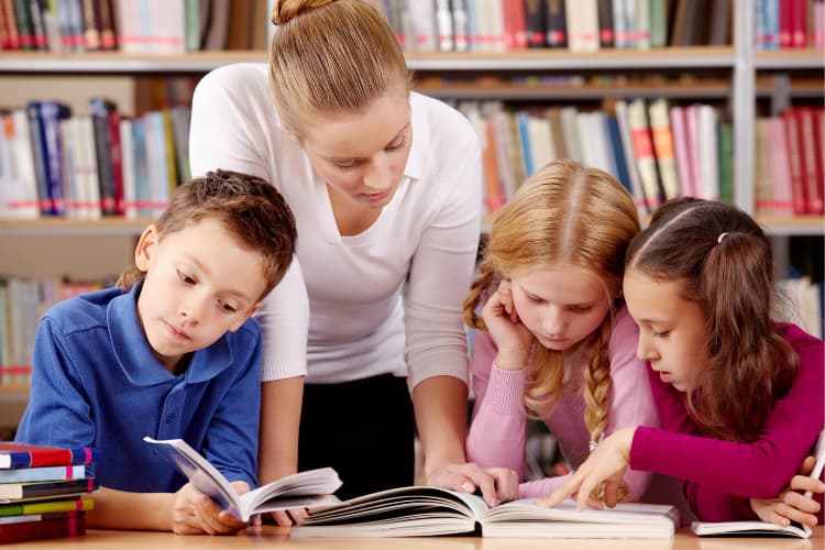 Teacher reading with students, representing EFNY programs that support French learning in NYC classrooms